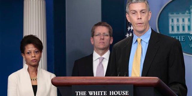Education Secretary Arne Duncan, right, accompanied by White House Press Secretary Jay Carney, center, and Domestic Policy Council Director Melody Barnes, speaks at the White House in Washington Aug. 8.