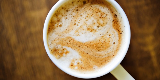 Heart shape on latte over wooden table
