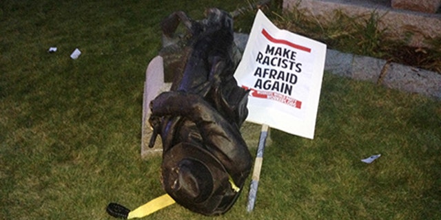 A toppled Confederate statue lies on the ground on Monday, Aug. 14, 2017, in Durham, N.C.