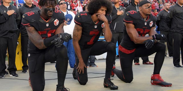 FILE 2016: San Francisco 49ers outside linebacker Eli Harold (58), quarterback Colin Kaepernick (7) and free safety Eric Reid (35) kneel in protest.