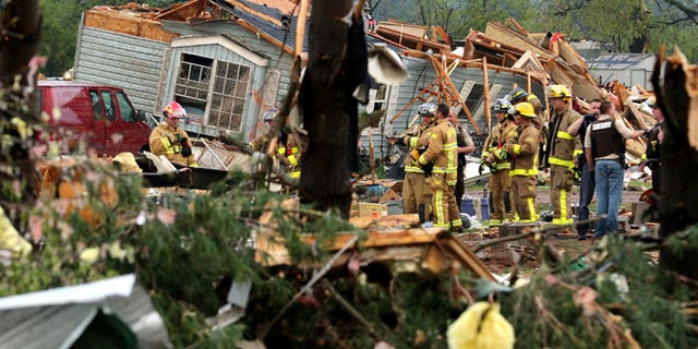 Firefighters work the site of the damage after a tornado ripped through Prairie Lake Estates trailer home park, just north of Chetek, Wis