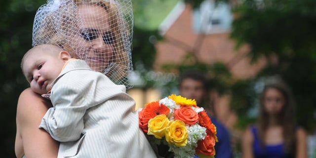 Aug. 3: Christine Swidorsky carries her son and the couple's best man, Logan Stevenson, down the aisle during the wedding ceremony in Jeannette, Pa.