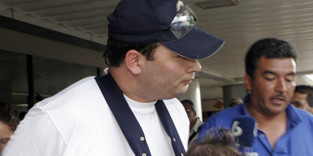 FILE - In this March 4, 2007 file photo Guatemala's former sub-director of the National Civil Police Javier Figueroa arrives with his family at International Airport Juan Santamaria in Alajuaela, Costa Rica. Austrian prosecutors have charged the former senior Guatemalan police official with murder in connection with the shooting deaths of seven prison inmates in his homeland, as it was announced Monday, May 13, 2013. (AP Photo/Kent Gilbert, File) EFE OUT