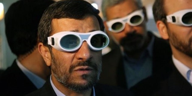 File: Iranian President Mahmoud Ahmadinejad, wears eye protection goggles as he visits an exhibition of Iran's laser science in Tehran.