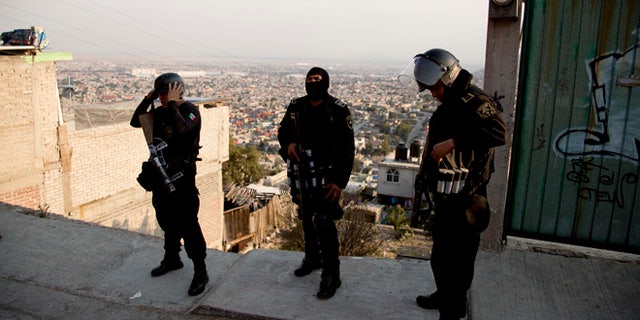 In this Jan. 19, 2015 photo, police officers prepare for an security operation in Ecatepec, a rough neighborhood on the outskirts of Mexico City. Pope Francis will hold the largest public event of his visit to Mexico when he celebrates Mass on an outdoor esplanade in Ecatepec on Feb. 14, 2016. (AP Photo/Eduardo Verdugo)