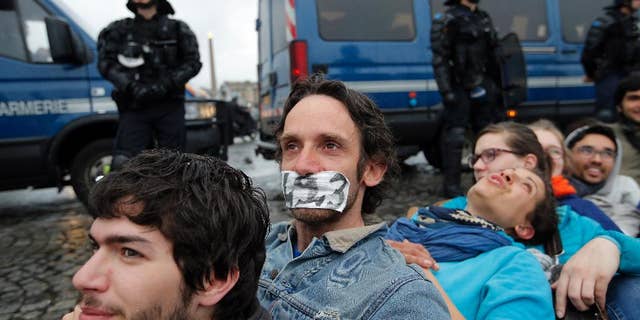 Demonstrators face policemen as they gather in front of the National Assembly to protest against the labor law, in Paris, Tuesday, May 10, 2016. The French government has decided to use special powers to pass a hotly contested labor reform without vote in the lower house of parliament.The decision to use the article 49-3 of the Constitution was made Tuesday after the government failed to find a compromise on the bill with legislators and convened a brief emergency Cabinet meeting. (AP Photo/Christophe Ena)