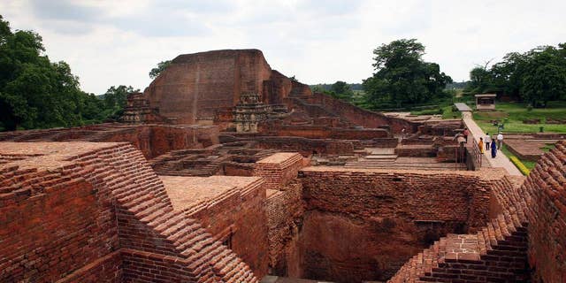 FILE � In this July 5, 2006 file photo, tourists walk at the ruins of the Nalanda University at Nalanda, India. UNESCO has put four new sites on its World Heritage List, including the archaeological site of Nalanda Mahavihara, or Nalanda University, on Friday, July 15, 2016. (AP Photo/Prashant Ravi, File)