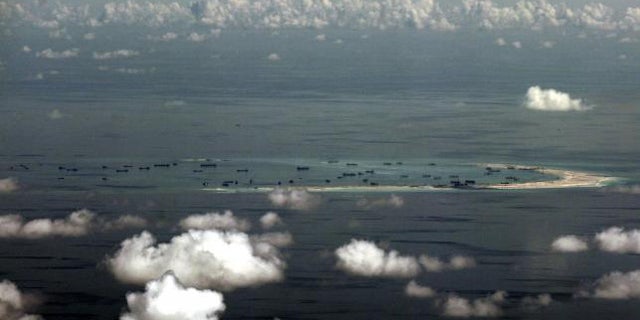 May 11, 2015: An aerial photo taken though a glass window of a Philippine military plane shows alleged on-going land reclamation by China on Mischief Reef in the Spratly Islands in the South China Sea, west of Palawan, Philippines. (REUTERS/RITCHIE B. TONGO)