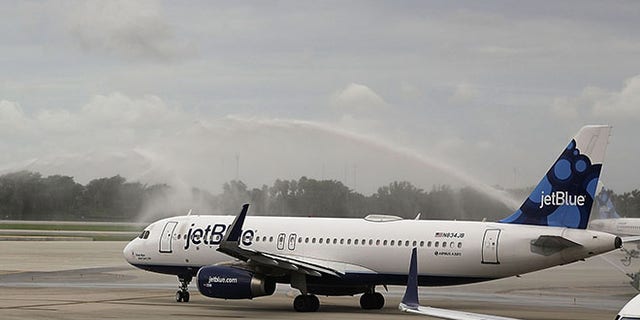 FORT LAUDERDALE, FL - AUGUST 31: Workers watch as JetBlue Flight 387 is given a water cannon salute as it prepares for take off to become the first scheduled commercial flight to Cuba since 1961 on August 31, 2016 in Fort Lauderdale, Florida. JetBlue which hopes to have as many as 110 daily flights is the first U.S. airline to resume regularly scheduled airline service under new rules allowing Americans greater access to Cuba. (Photo by Joe Raedle/Getty Images)