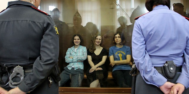 Aug. 17, 2012: Feminist punk group Pussy Riot members, from left, Yekaterina Samutsevich, Maria Alekhina and Nadezhda Tolokonnikova sit in a glass cage at a court room in Moscow, Russia .