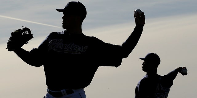 San Diego Padres pitchers Clayton Richard, left, and Fautino De Los Santos throw during a spring training baseball workout on Friday, Feb. 15, 2013, in Peoria, Ariz. (AP Photo/Charlie Riedel)