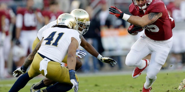 Stanford running back Tyler Gaffney, right, runs against Notre Dame during the first half of an NCAA college football game on Saturday, Nov. 30, 2013, in Stanford, Calif. Stanford won 27-20. (AP Photo/Marcio Jose Sanchez)