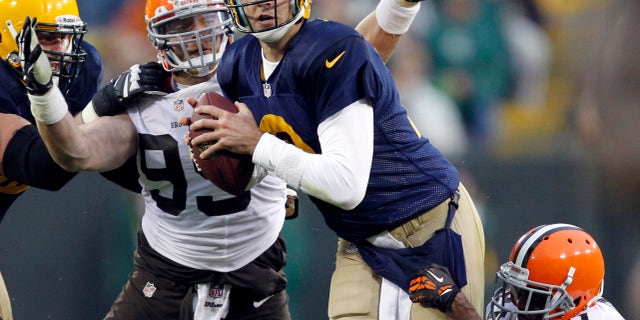 Green Bay Packers quarterback Aaron Rodgers is sacked by Cleveland Browns' Chris Owens (21) and Paul Kruger during the second half of an NFL football game Sunday, Oct. 20, 2013, in Green Bay, Wis. (AP Photo/Mike Roemer)