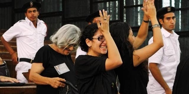 Prominent Egyptian blogger Alaa Abdel-Fattah's mother, Laila Soueif, a university professor who is an also an activist, background left, his sister Mona Seif, wearing eyeglasses at center, and his wife, Manal Bahy Eddin Hassan at right, cheer after his release on bail at a courtroom in Cairo, Egypt, Monday, Sept. 15, 2014. Relatives say that Egypt's most prominent activist who is standing retrial after being sentenced to 15 years in prison for violating to the country's draconian protest law, has been released on bail. (AP Photo/Ravy Shaker, El Shorouk) EGYPT OUT