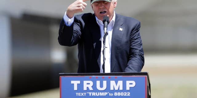 FILE - In this June 3, 2016 file photo, Republican presidential candidate Donald Trump gestures to a his camouflaged "Make America Great" hat at a campaign rally at the Redding Municipal Airport in Redding, Calif. Trump's prediction that he can win California in the November presidential election challenges the dismal history for Republican nominees in one of the nation's Democratic strongholds. (AP Photo/Rich Pedroncelli)