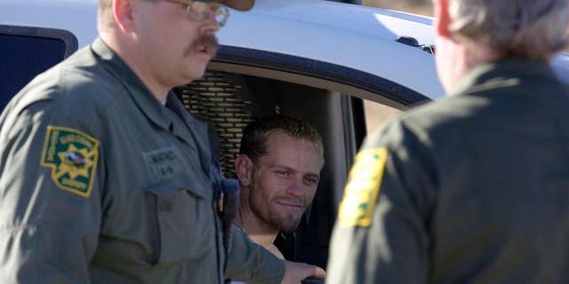 FILE - In this Jan. 3, 2012, file photo, Utah murder suspect Logan Welles McFarland looks out from a Elko County Sheriff's Deputy vehicle after being caught south of Oasis, Nev., near the Big Springs Ranch. McFarland, a man accused of killing two people during a string of crimes committed in Utah and Nevada with his girlfriend pleaded guilty Wednesday, Jan. 25, 2017, in a deal that lets him avoid the death penalty. McFarland was sentenced in Utah to serve two life prison terms, one on each count of aggravated murder. (Ross Andreson /The Daily Free Press via AP, File)
