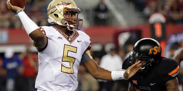 FILE - In this Aug. 30, 2014, file photo, Florida State quarterback Jameis Winston (5) passes under pressure from Oklahoma State linebacker Josh Furman (14) during an NCAA college football game in Arlington, Texas. Things didn't come nearly as easy for the Heisman winner, and the FSU offense will need to play much better if the Seminoles are to win the first College Football Playoff. (AP Photo/Tony Gutierrez, File)