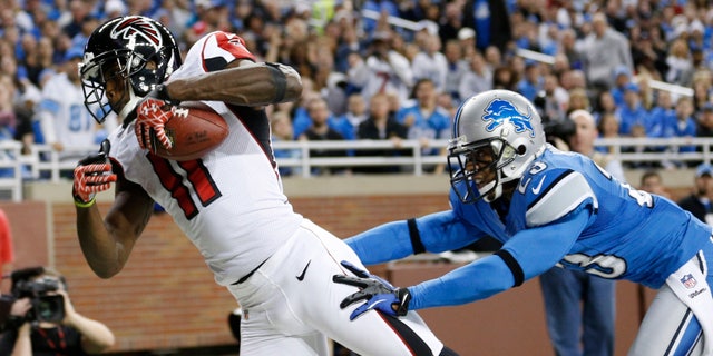 FILE- In this Dec. 22, 2012, file phot, Atlanta Falcons wide receiver Julio Jones (11) falls into the end zone for a 16-yard touchdown as Detroit Lions cornerback Chris Houston defends during the second quarter of an NFL football game at Ford Field in Detroit. In his second year with the Falcons, Jones says he's grateful to have a position coach so dedicated to his success. (AP Photo/Rick Osentoski)
