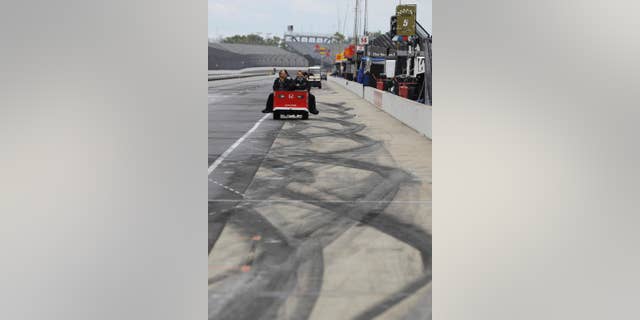 The crew for Carlos Munoz, of Colombia, leave the pits after a practice session for the Indianapolis 500 auto race was cancelled due to weather at Indianapolis Motor Speedway in Indianapolis, Tuesday, May 17, 2016,. (AP Photo/Darron Cummings)