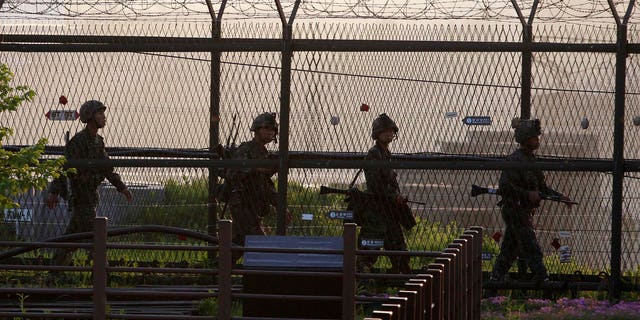 South Korean Army soldiers patrol along a barbed-wire fence near the border village of the Panmunjom in Paju, South Korea, Monday, May 20, 2103. North Korea fired short-range projectiles into its own eastern waters Monday for a third straight day, Seoul officials said. The North said it was bolstering deterrence against enemy attack. (AP Photo/Ahn Young-joon)