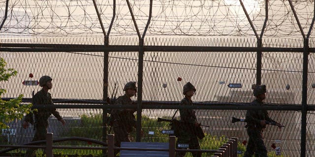 South Korean Army soldiers patrol along a barbed-wire fence near the border village of the Panmunjom in Paju, South Korea, Monday, May 20, 2103. North Korea fired short-range projectiles into its own eastern waters Monday for a third straight day, Seoul officials said. The North said it was bolstering deterrence against enemy attack. (AP Photo/Ahn Young-joon)