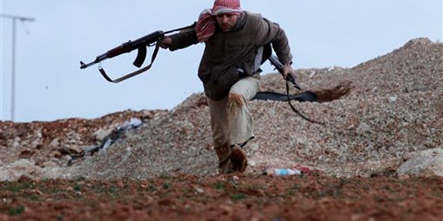 Feb. 8, 2012: A Syrian rebel runs for cover during an exchange of fire with army troops, unseen, in Idlib, Syria.