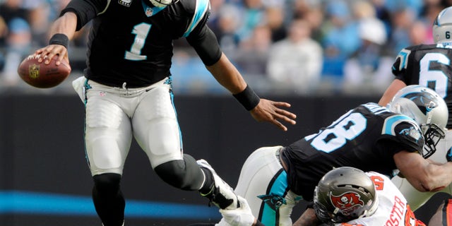 Carolina Panthers' Cam Newton (1) dodges Tampa Bay Buccaneers' Mason Foster (59) in the first half of an NFL football game in Charlotte, N.C., Sunday, Dec. 1, 2013. (AP Photo/Mike McCarn)