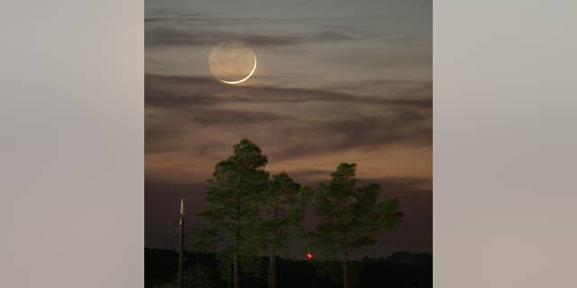 FILE - In this Jan. 9, 2008, file photo, one day past New, an early Waxing Crescent Moon is seen just after sunset from Tyler, Texas. A rare "black moon" rises over the Western Hemisphere on Friday, Sept. 30, 2016. A black moon is the second new moon in a calendar month. (AP Photo/Dr. Scott M. Lieberman, File)