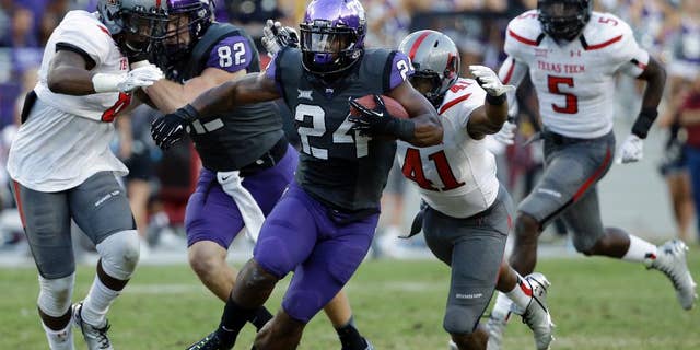 TCU running back Trevorris Johnson (24) attempts to evade a tackle by Texas Tech's Malik Jenkins (41) in the second half of an NCAA college football game, Saturday, Oct. 25, 2014, in Fort Worth, Texas. TCU won 82-27. (AP Photo/Tony Gutierrez)