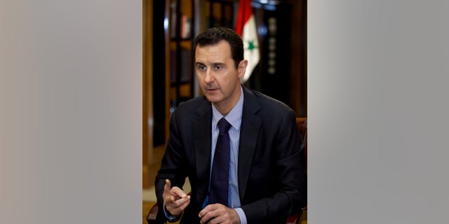 In this photo, which AP obtained from Syrian official news agency SANA and which has been authenticated based on its contents and other AP reporting, President Bashar Assad gestures as he speaks during an interview with Lebanon’s Al-Mayadeen TV, at the presidential palace in Damascus, Syria, Monday, Oct. 21, 2013. Syria’s president said Monday that the factors that would allow a landmark conference aimed at ending the country’s civil war do not yet exist, throwing further doubt on international efforts to hold peace talks that have already been repeatedly delayed. (AP Photo/SANA)