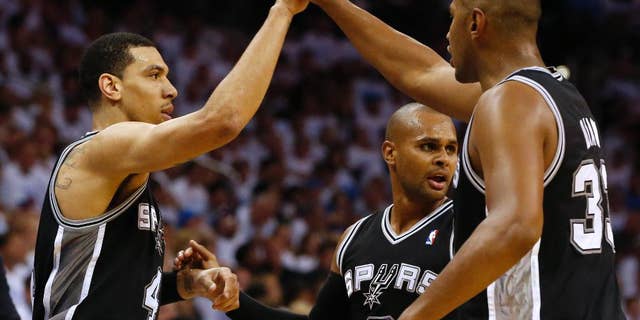 From left, San Antonio Spurs' Danny Green, Patty Mills, and Boris Diaw celebrate during the second half against the Oklahoma City Thunder in Game 6 of the Western Conference finals NBA basketball playoff series in Oklahoma City, Saturday, May 31, 2014. (AP Photo/Sue Ogrocki)