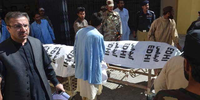 People carry dead bodies of paramilitary officers killed by gunmen in Quetta, Pakistan, Friday, Oct. 14, 20165. Gunmen riding on motorcycles shot and killed three paramilitary officers Friday in the southwestern Pakistani city of Quetta before fleeing, official said. The attack on FC guards, the Islamic State group claimed responsibility for the killing the three guards on street in Quetta, though there is no visible sign of IS in the city. (AP Photo/Arshad Butt)