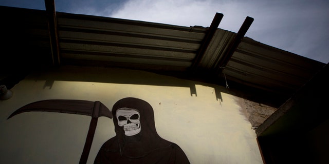 A mural of La Santa Muerte, or Saint Death, decorates the wall of a community center in Colonias, Michoacan state, Mexico, where vigilantes met with the families of a Tuesday shooting that took place in nearby Apatzingan, on Thursday, Jan. 8, 2015.  Confrontations in Apatzingan began Tuesday when federal forces moved in to take control of city hall, which had been held for days by civilians whose demands and identities were unclear, according to Michoacan state Commissioner Alfredo Castillo. The second clash came when gunmen attacked soldiers who were transporting the seized vehicles to an impound lot, Castillo said. However, family members and witnesses tell a different story, one with a higher death toll. (AP Photo/Rebecca Blackwell)