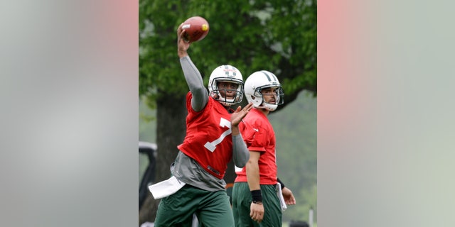 New York Jets' Geno Smith (7) throws a pass as Mark Sanchez (6) looks on as the quarterbacks practice during NFL football workouts in Florham Park, N.J., Wednesday, May 22, 2013. (AP Photo/Mel Evans)