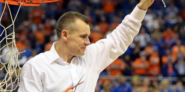 Florida coach Billy Donovan holds up a piece of the net after the Gators became the first team in Southeastern Conference history to go 18-0 in league pla, Saturday, March 8, 2014 in Gainesville, Fla. Florida defeated Kentucky 84-65 Saturday in an NCAA college basketball game. (AP Photo/Phil Sandlin)
