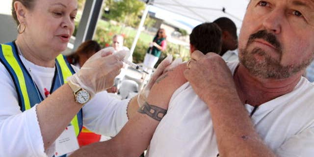 NAPA, CA - OCTOBER 02: Beth Deenihan (L) adminsters a flu shot to a construction worker during a drive-thru flu shot clinic October 2, 2009 in Napa, California. The County of Napa Public Health Department held the one of eight scheduled drive-thru flu shot clinics where seasonal flu shots will be given for free to anyone who attends in an effort to vaccinate as many people in Napa County as possible before the start of the flu season. (Photo by Justin Sullivan/Getty Images)