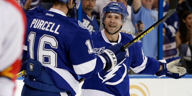Tampa Bay Lightning right wing Martin St. Louis, right, celebrates with teammate Teddy Purcell after scoring against the Florida Panthers during the second period of an NHL hockey game Saturday, April 27, 2013, in Tampa, Fla. (AP Photo/Chris O'Meara)
