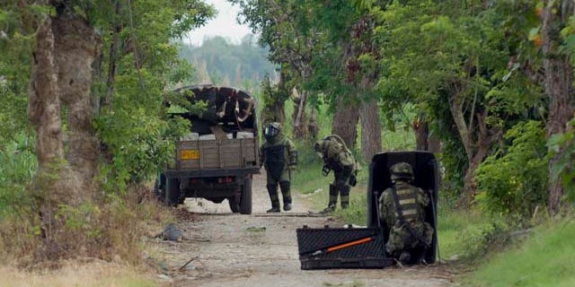 Members of a police bomb squad inspect a truck believed to be loaded with explosives in Corinto, southern Colombia, Tuesday June 21, 2011. The officers did not find explosives in the vehicle, instead they found one ton of marijuana. Rebels of the Revolutionary Armed Forces of Colombia, FARC, and the National Liberation Army, ELN, are active in the region. (AP Photo/Carlos Julio Martinez)