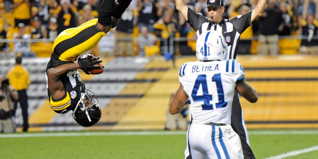 Pittsburgh Steelers wide receiver Antonio Brown (84), left, flips into the end zone over Indianapolis Colts defensive back Antoine Bethea (41) for a touchdown in the first quarter of an NFL football preseason game on Sunday, Aug. 19, 2012 in Pittsburgh. (AP Photo/Don Wright)
