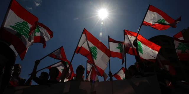 Lebanese people wave the nation's flag, in downtown Beirut, March 19, 2017.