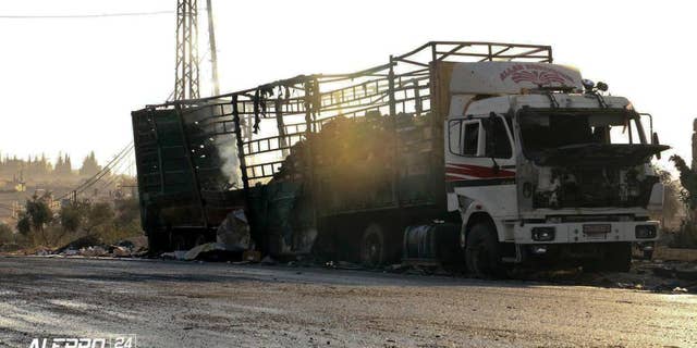 This image provided by the Syrian anti-government group Aleppo 24 news, shows a vest of the Syrian Arab Red Crescent hanging on a damaged vehicle, in Aleppo, Syria, Tuesday, Sept. 20, 2016. A U.N. humanitarian aid convoy in Syria was hit by airstrikes Monday as the Syrian military declared that a U.S.-Russian brokered cease-fire had failed, and U.N. officials reported many dead and seriously wounded. (Aleppo 24 news via AP)