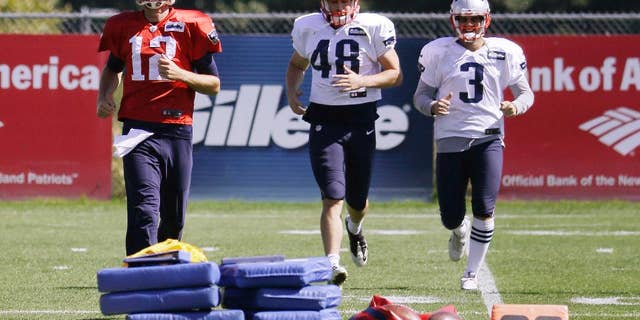 New England Patriots quarterback Tom Brady (12), long snapper Danny Aiken (48) and kicker Stephen Gostkowski (3) run during a stretching session before practice begins at the NFL football team's facility Wednesday, Sept. 17, 2014 in Foxborough, Mass. (AP Photo/Stephan Savoia)