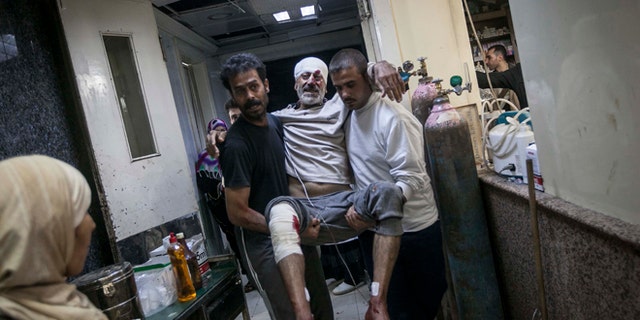 Nov. 13, 2012: A Syrian man is carried in the arms of his relatives at a hospital after he was injured by a mortar shell explosion in the Bab Al-Nayrab neighborhood of Aleppo, Syria.