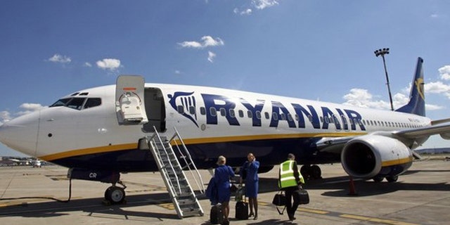 Ryanair crew stand in front of the airline's passenger jet on the tarmac of Marignane airport in Marseille in this May 10, 2006 file photo. Low-cost airline Ryanair has been charged with illegal working practices after the Irish budget airline declared 120 employees in France as working in Ireland, a justice source said on September 28, 2010. REUTERS/Jean-Paul Pelissier/Files (FRANCE - Tags: TRANSPORT EMPLOYMENT BUSINESS CRIME LAW)