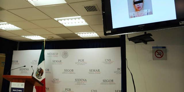 A woman identified by authorities as Clara Laborin Archuleta, wife of jailed drug lord Hector Beltran Leyva, is shown on a monitor during a news conference by federal police in Mexico City, Tuesday, Sept. 13, 2016. Federal police say Archuleta was arrested on Monday in the northern state of Sonora. She's alleged to have been involved in efforts to reassert her husband’s gang’s control over criminal operations in the Pacific coast resort city of Acapulco. (AP Photo/Marco Ugarte)