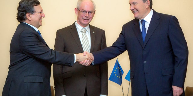 Ukraine's President Viktor Yanukovych, right, shakes hands with European Commission President Jose Manuel Barroso, left, and European Council President Herman van Rompuy, center, in Vilnius, Lithuania, Thursday, Nov 28, 2013. Van Rompuy and Barroso met with Yanukovych hours before Thursday's start of the Vilnius summit in an attempt to cajole him into signing the long-planned association agreement as soon as possible after the two-day meeting. (AP Photo/ Mykhailo Markiv, Pool)
