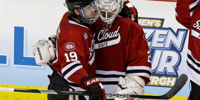 St. Cloud State goalie Ryan Faragher, right, is hugged by Drew LeBlanc (19) after losing 4-1 to Quinnipiac in an NCAA college hockey Frozen Four semifinal game in Pittsburgh, Thursday, April 11, 2013. Quinnipiac faces Yale in the national championship game on Saturday. (AP Photo/Gene J. Puskar)