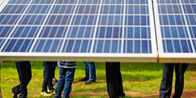Guests tour a solar panel project built on farmland that former President Carter owns in Georgia.