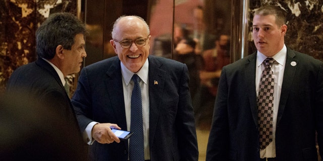 Former New York Mayor Rudy Giuliani, center, smiles as he leaves Trump Tower, Friday, Nov. 11, 2016, in New York. (AP Photo/Evan Vucci)