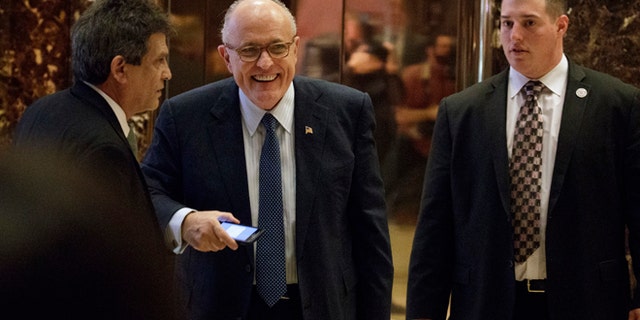 Former New York Mayor Rudy Giuliani, center, smiles as he leaves Trump Tower, Friday, Nov. 11, 2016, in New York. (AP Photo/Evan Vucci)